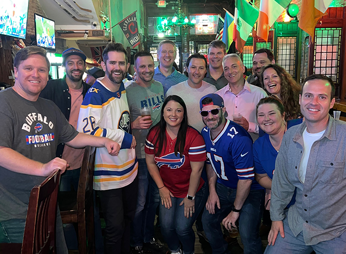 A group of ITX team Members at a bar wearing their favorite sport team shirt